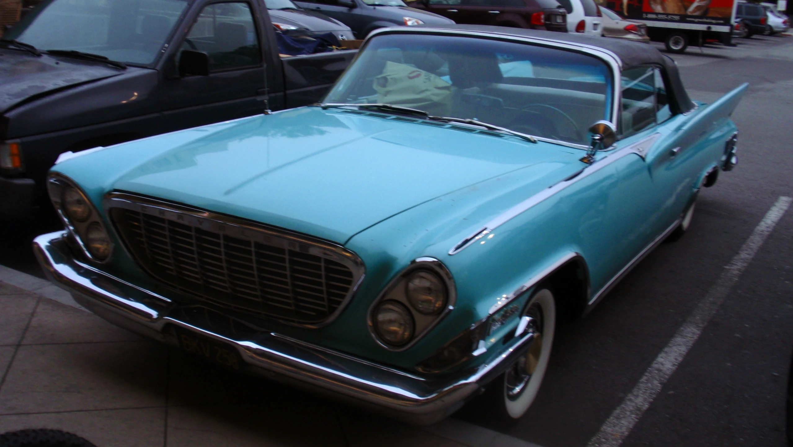 the old model car is parked in the parking lot