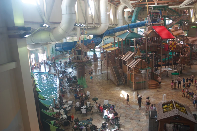 people walk near water slides in a large indoor waterspark