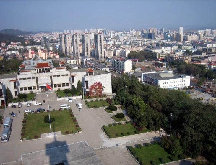 a large building in the middle of a city with a lot of trees