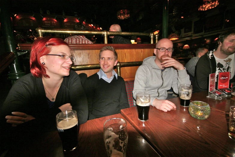 a group of people sitting around a wooden table