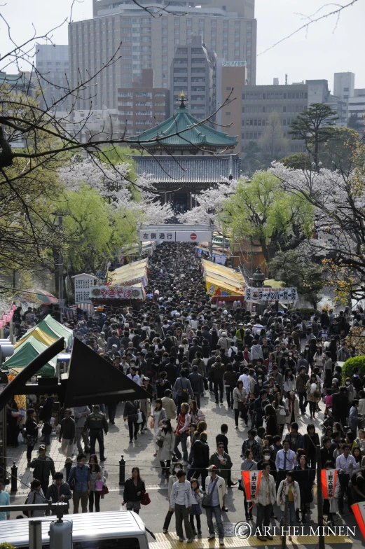 crowd of people standing in street next to tall buildings