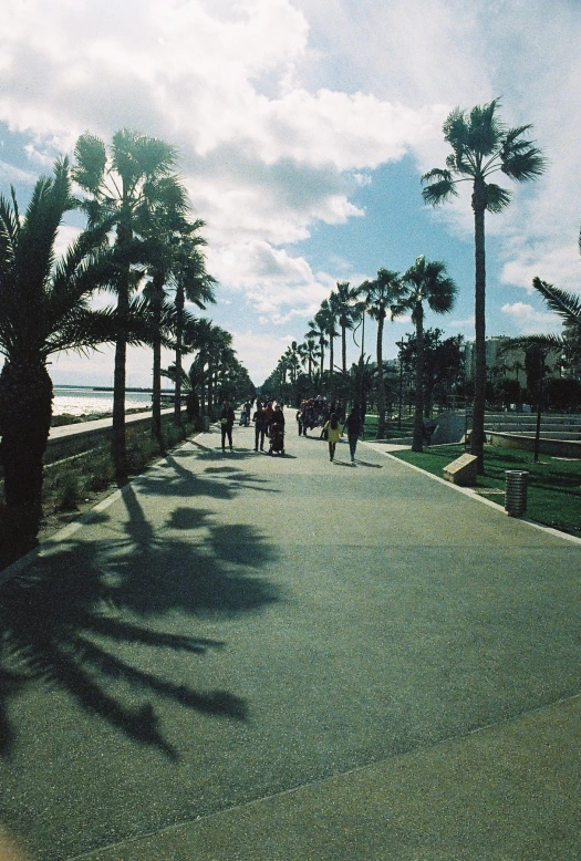 people are walking on the walkway near the ocean