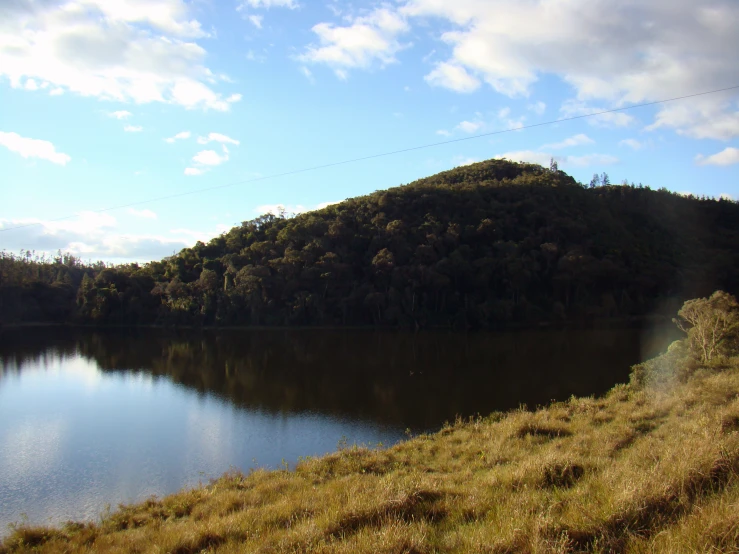 a scenic view of a lake and hills with trees