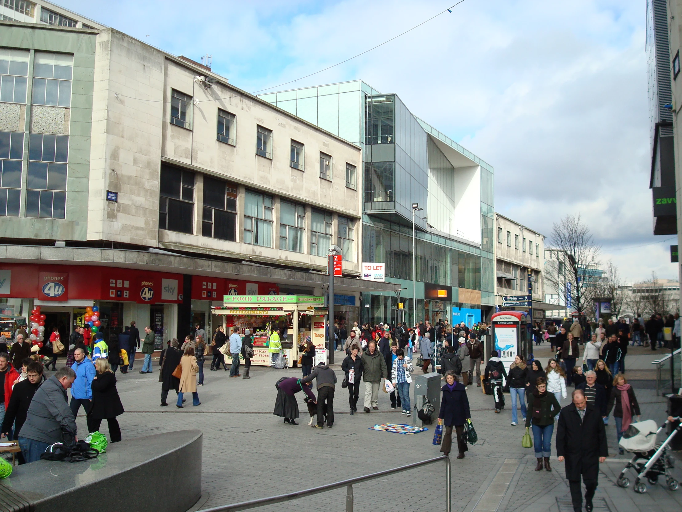 a group of people walking around a city square