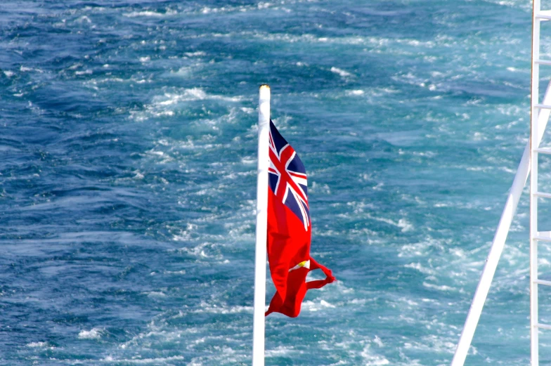 there is a british flag flying next to the ocean