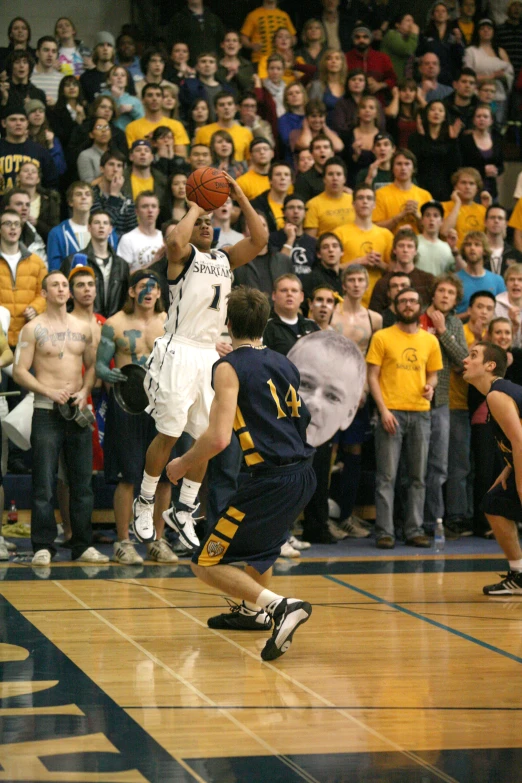 an audience watching a basketball game being played on a court