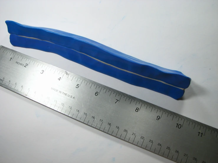 the side measuring ruler and plastic blue item on the table