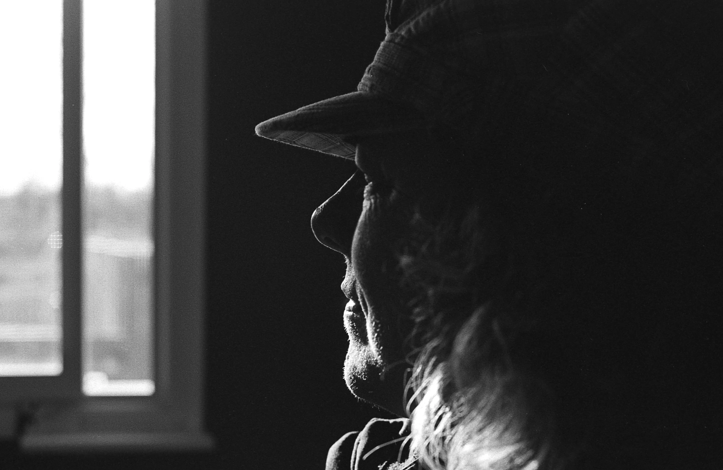 a person in a hat is looking out of a window