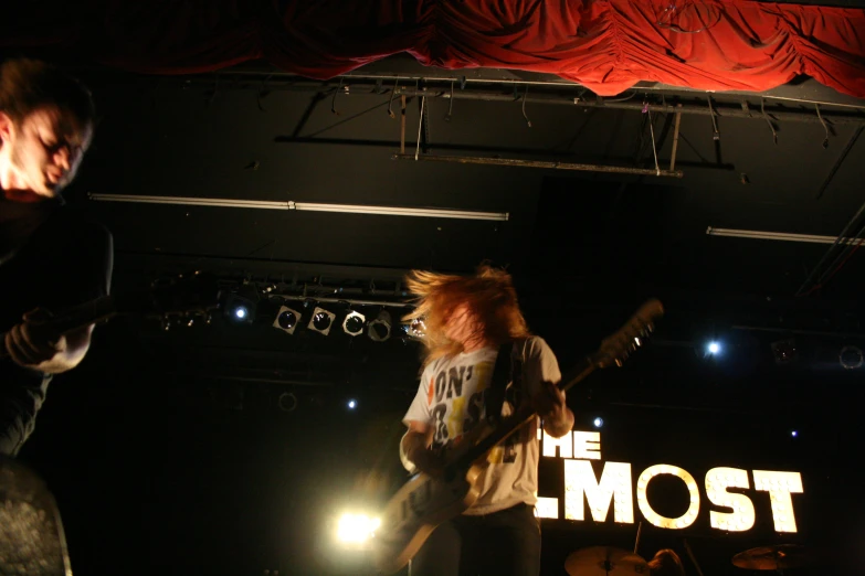 two guitarists on stage performing with the word'the most '