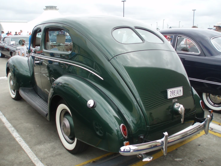 a vintage car is parked near other old cars