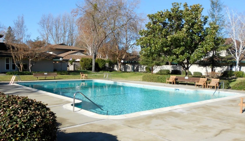 a large swimming pool with several brown chairs next to it