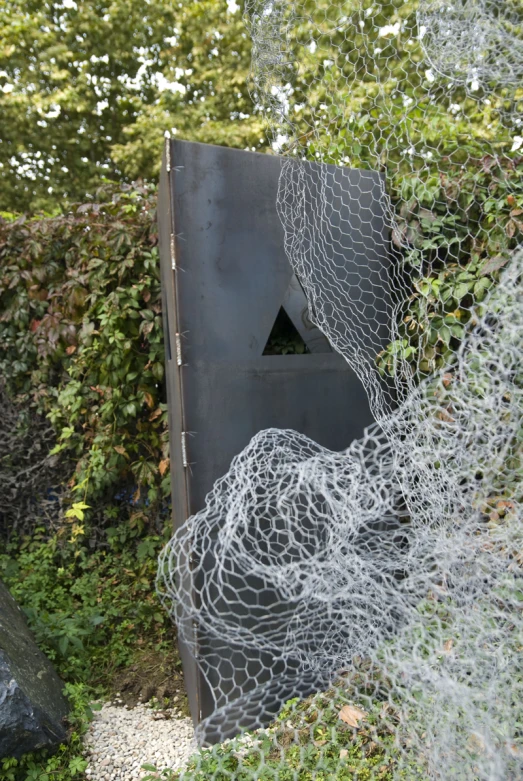 a sculpture is shown behind some vines