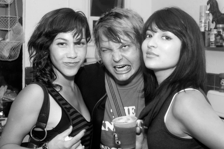 three girls are posing with a drink in a black and white po