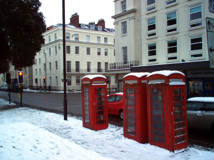 two red phone booths sitting on the side of a road