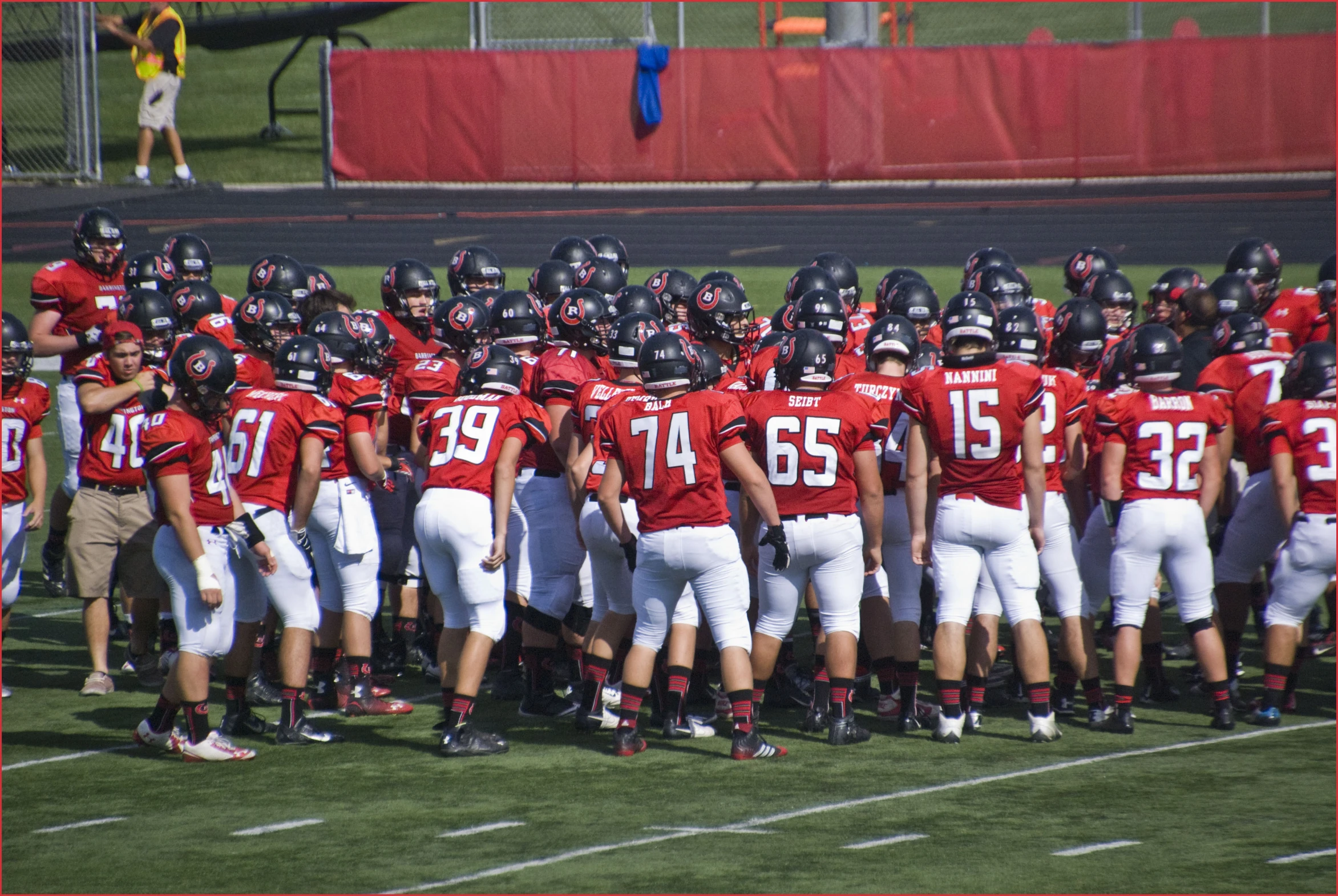 there are many football players wearing helmets standing together