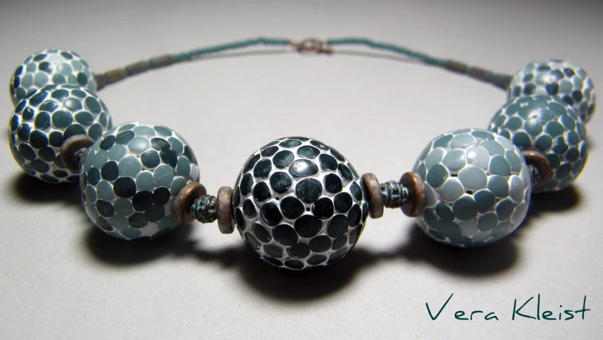 a blue necklace with beads that have dots and circles