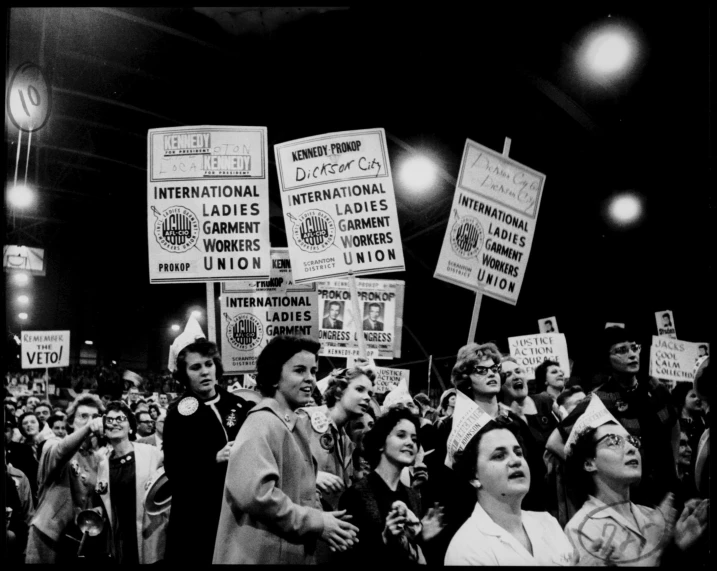 a group of women standing around a crowd with signs