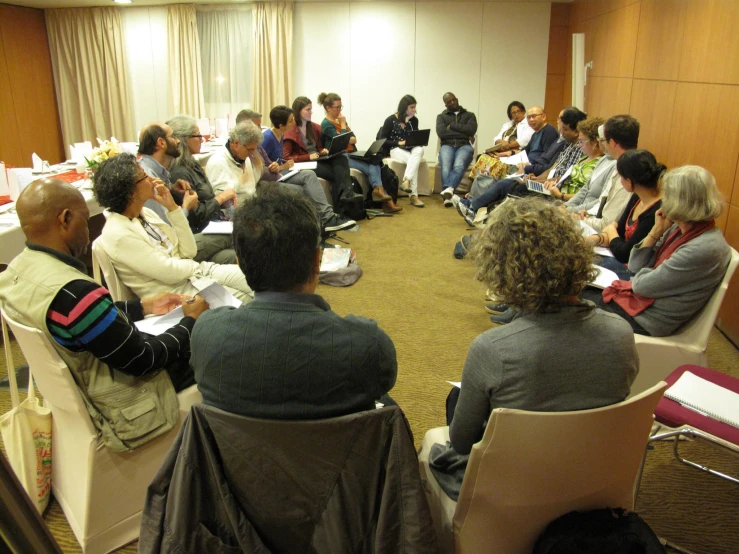a group of people sitting in chairs during a meeting