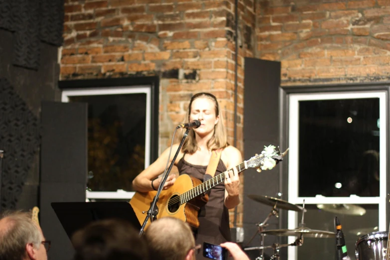 a woman that is standing with a guitar