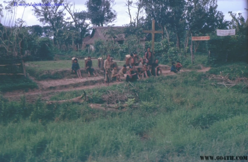 men, horses and oxen walk along the dirt road