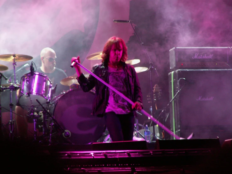 a band playing on stage with purple lights