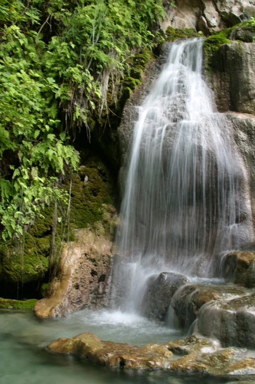 a waterfall next to a body of water