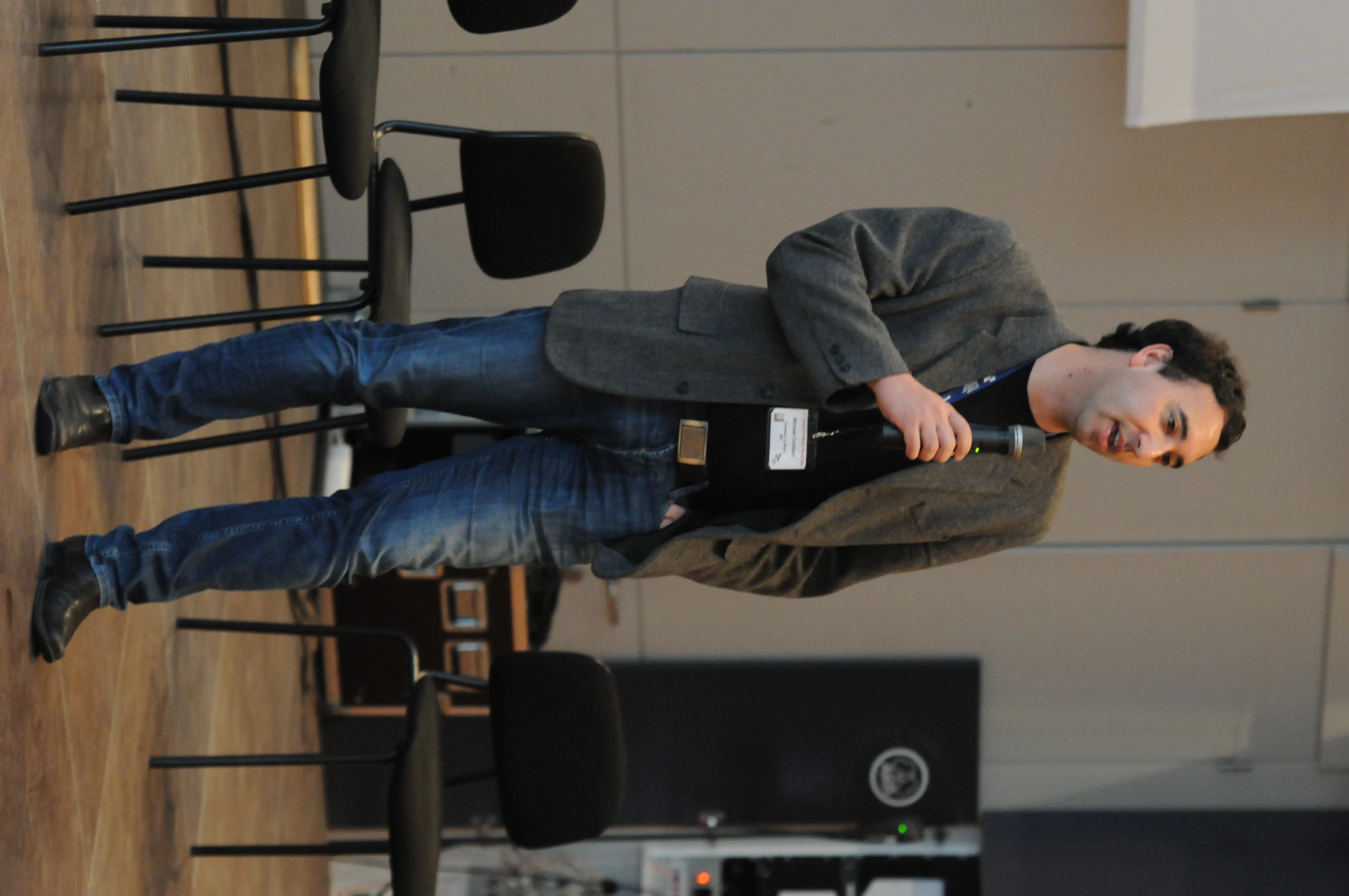 man standing in front of a table talking into microphone