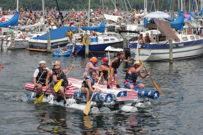 the men are on boats in the water with a crowd of people