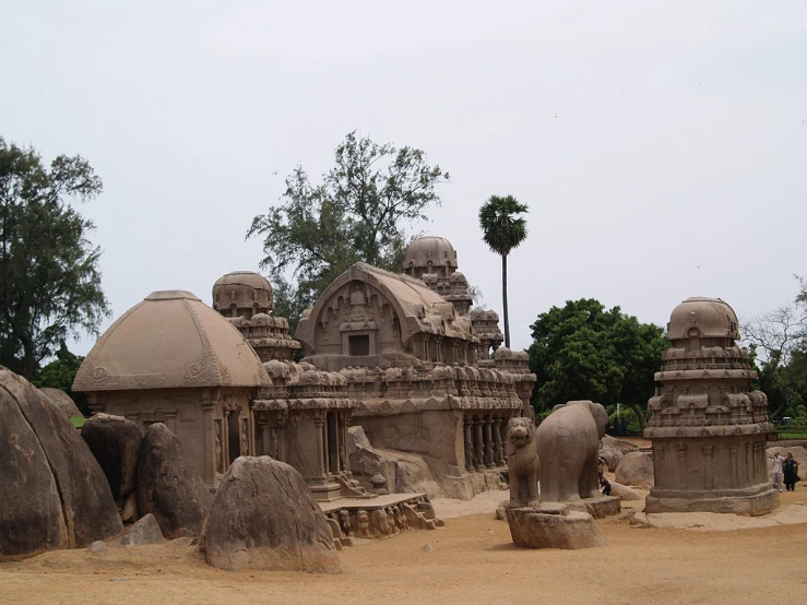 elephant statues in front of a line of ancient temples