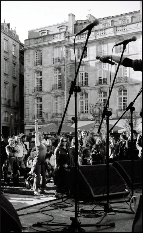 the man is standing at a microphone in front of a crowd