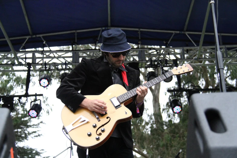 a man holding onto his guitar on stage