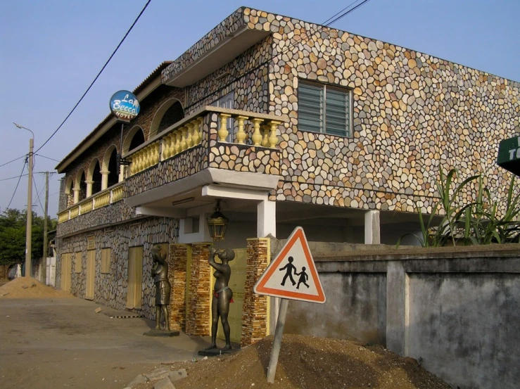 a building made of rocks next to a street sign