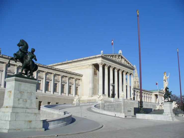 a building in the center of a city with a statue outside of it