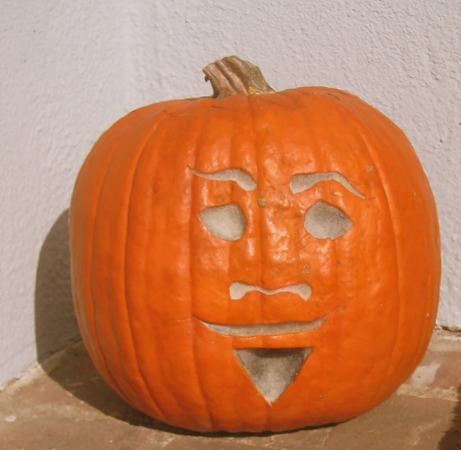 a carved pumpkin with its face has been cut in half