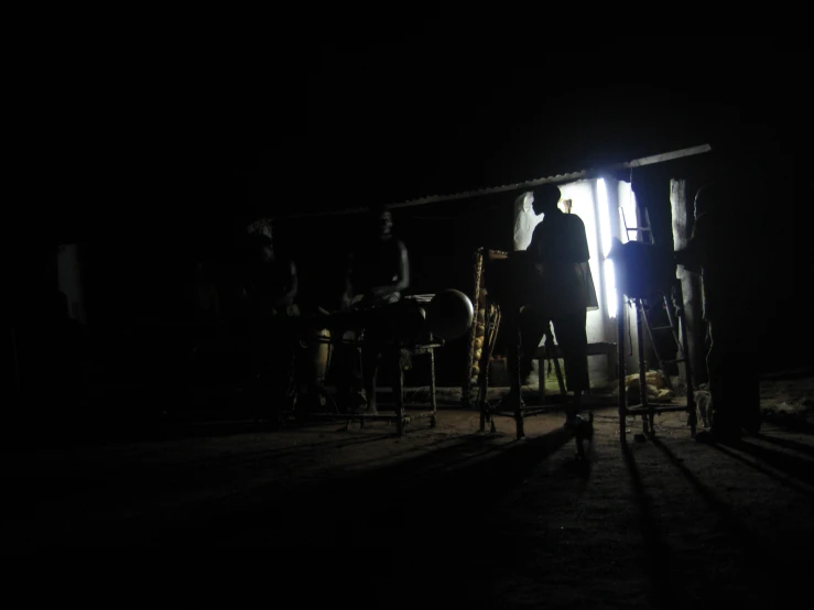 people in the dark standing at a door