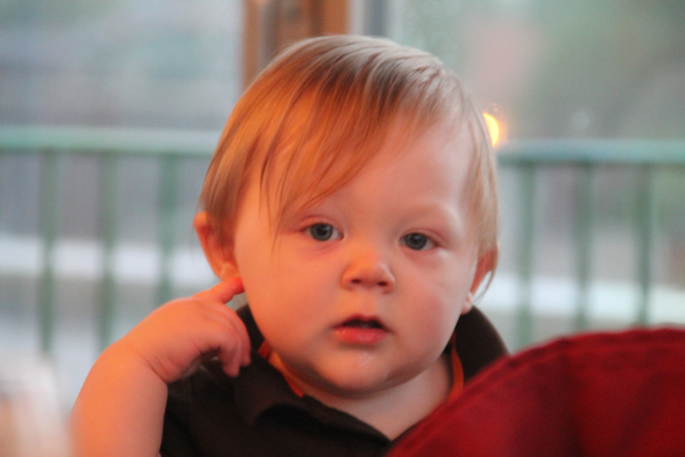 an adorable little boy holding his ears up