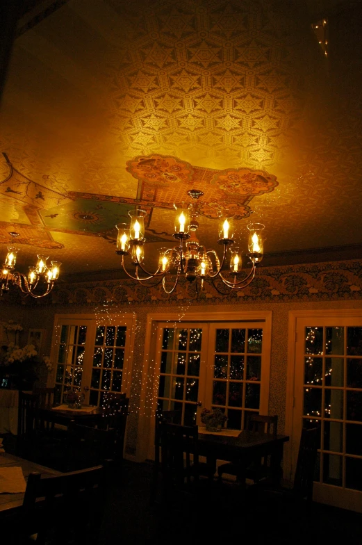 a chandelier hanging from the ceiling above a long dining room table