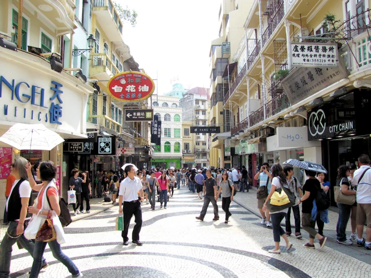 many people walking down the street and several buildings