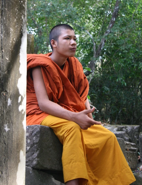 a person that is sitting down on a rock