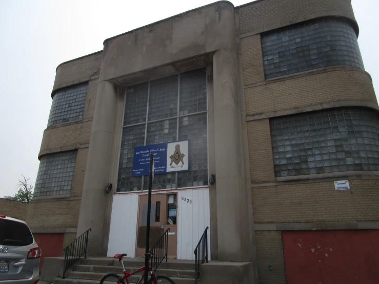 the building has a bicycle and other cars outside it