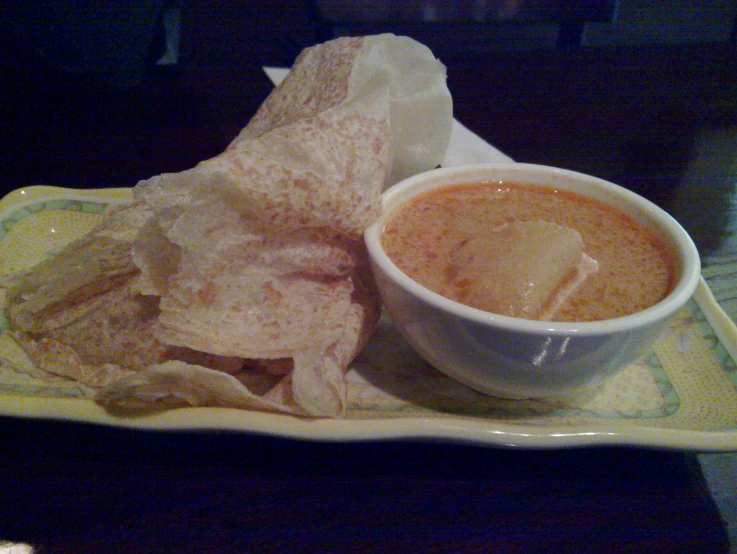 a tray holding chips and a cup of dipping sauce