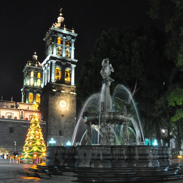 a night time view of the fountain and clock tower