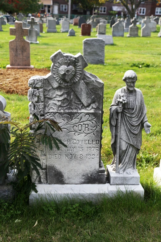 a cemetery with several statues of people in the graveyard