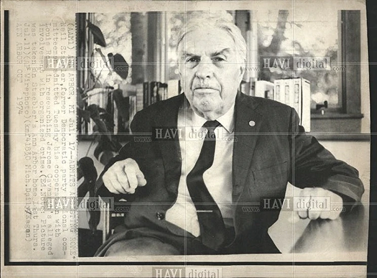 an old pograph of an older man sitting at a table