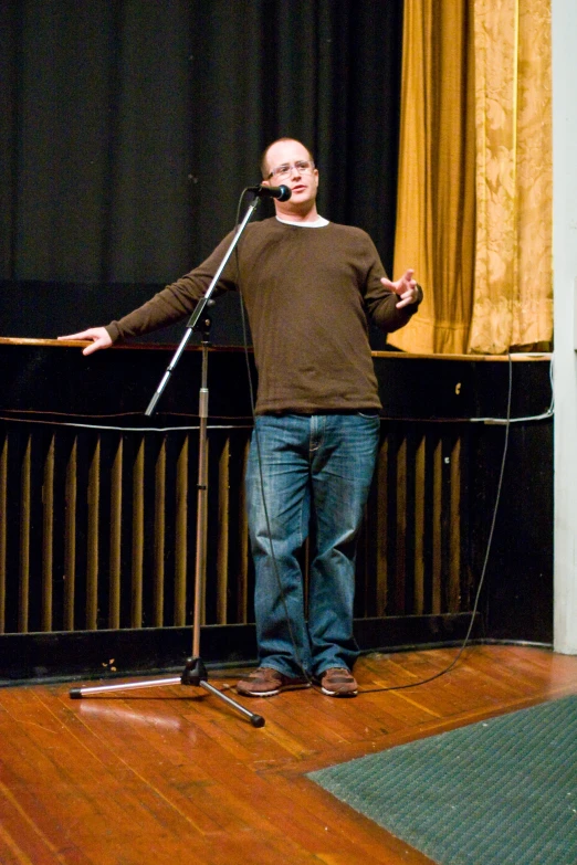 a man is talking into microphone in front of a podium