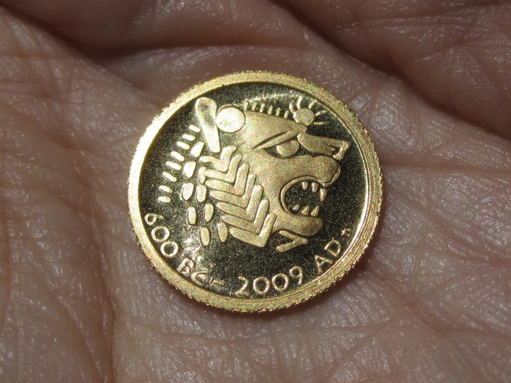 a person holding out their fingers with an antique looking coin