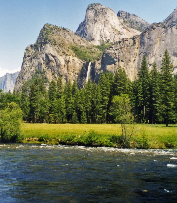 a river flows through the valley with lush greenery