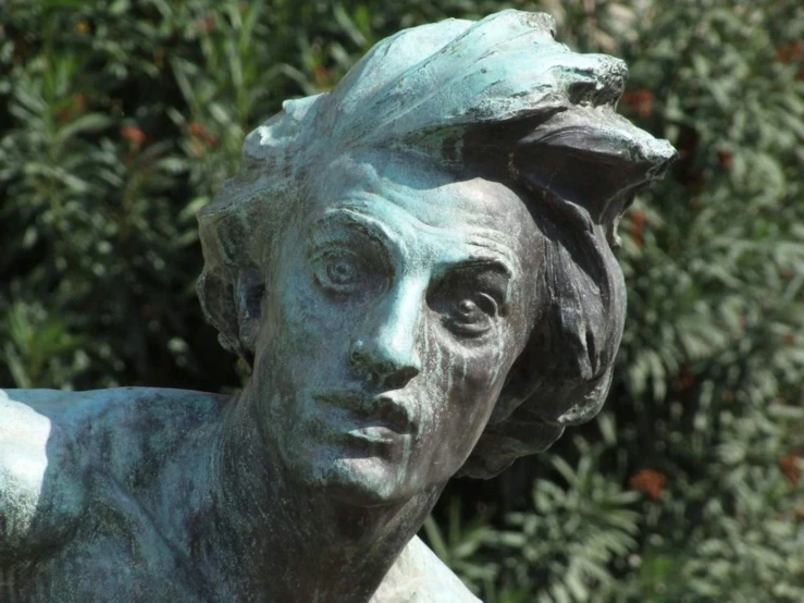 a bronze statue of a woman that has a hair on top