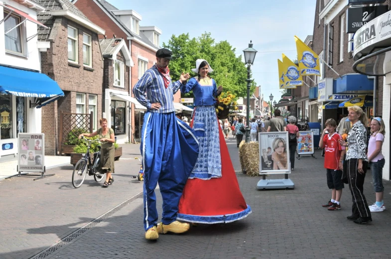 the man and woman are dressed in traditional clothing on the street