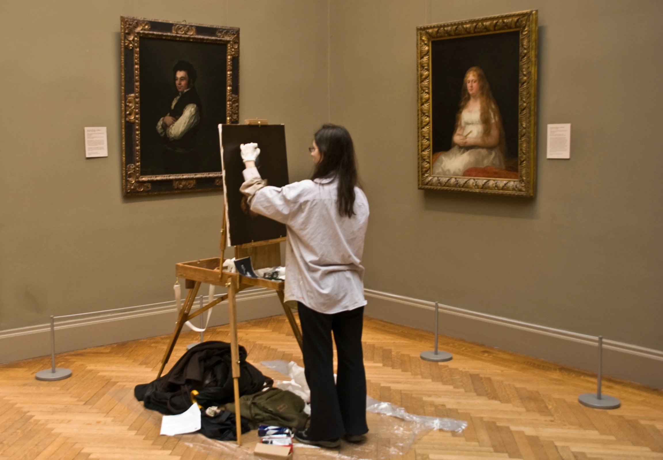 a woman is standing and taking pictures of some paintings